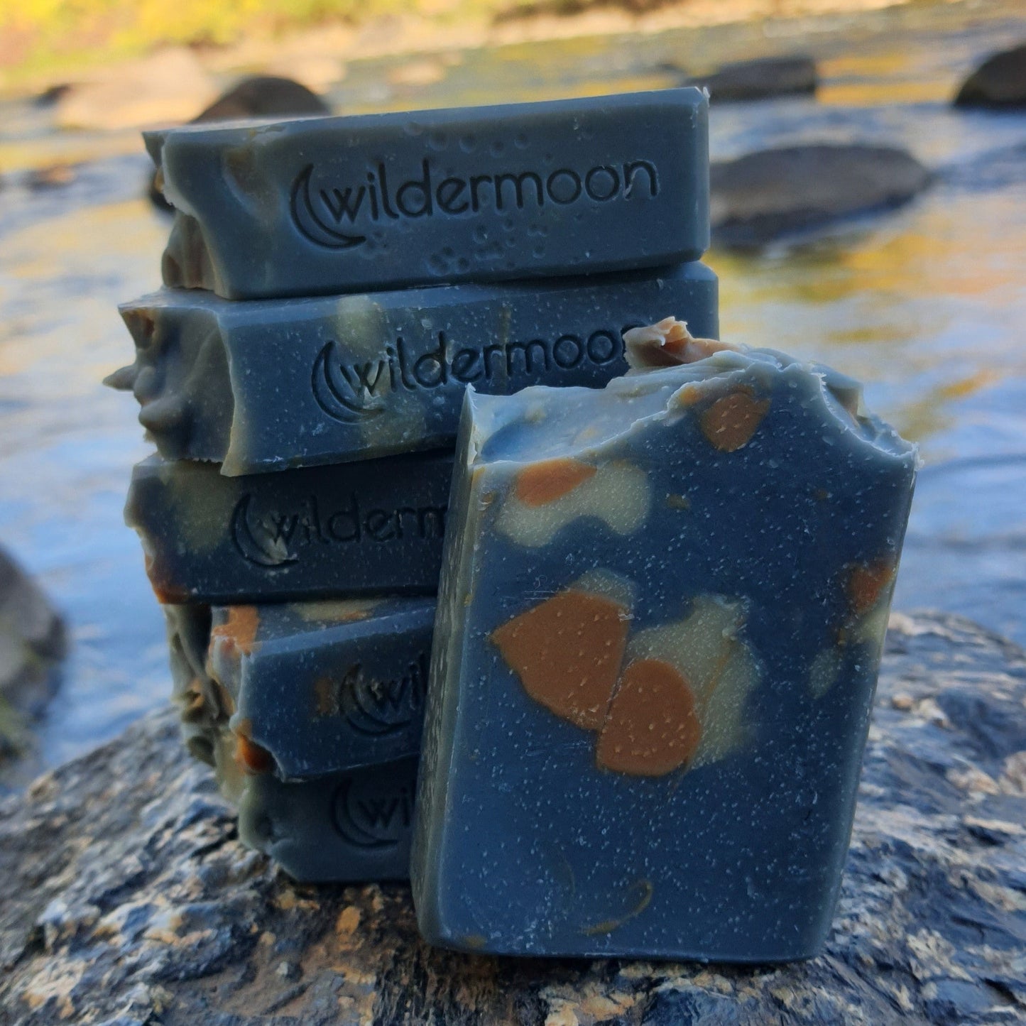 Apothecary artisan soap. Rectangular navy blue soap with orange and white design and wildermoon logo stamp on side