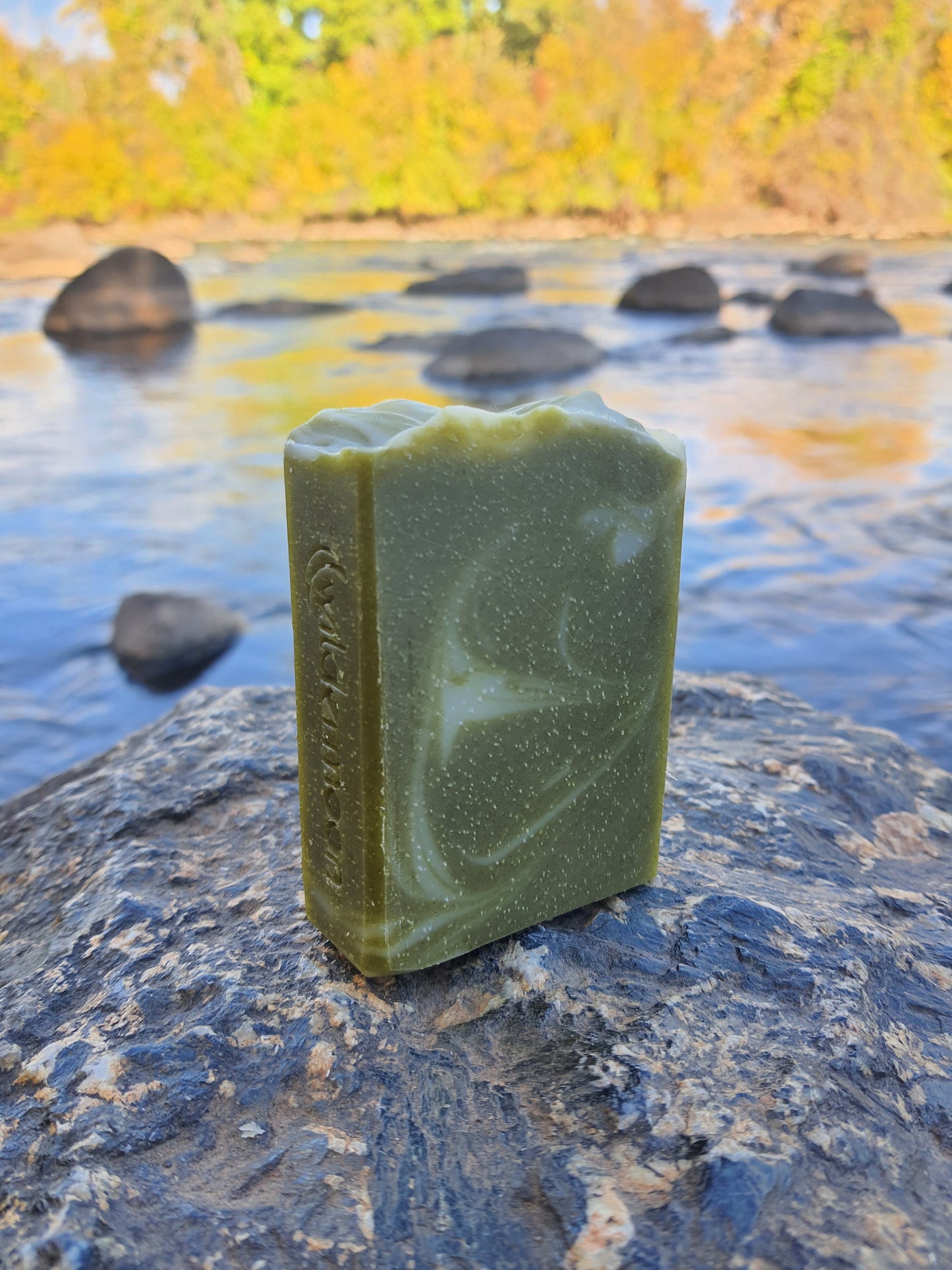Herb garden artisan soap. Rectangular forest green soap with white swirls and wildermoon logo stamp on the side