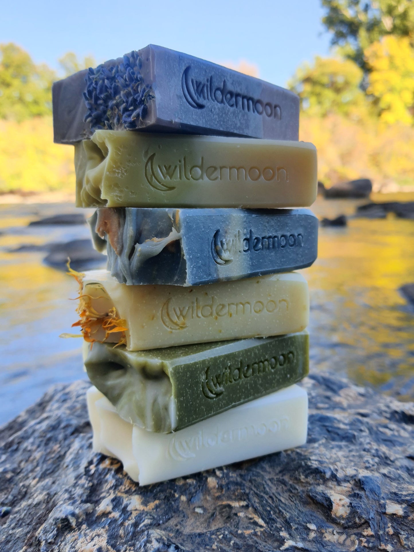 stack of a variety of wildermoon soaps in different colors and scents